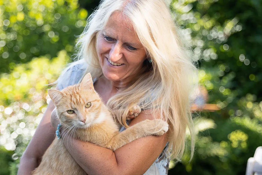 Daniela Fischer ist die Inhaberin der Praxis Larimar in Nideggen. SIe hält eine Katze auf den Arm und schaut diese an.